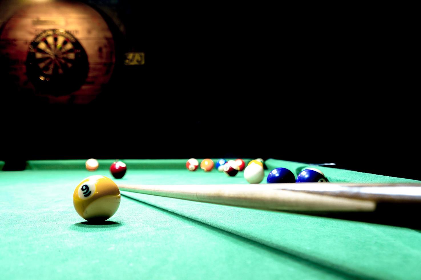 Billiard table and a dart boart on the wall photo