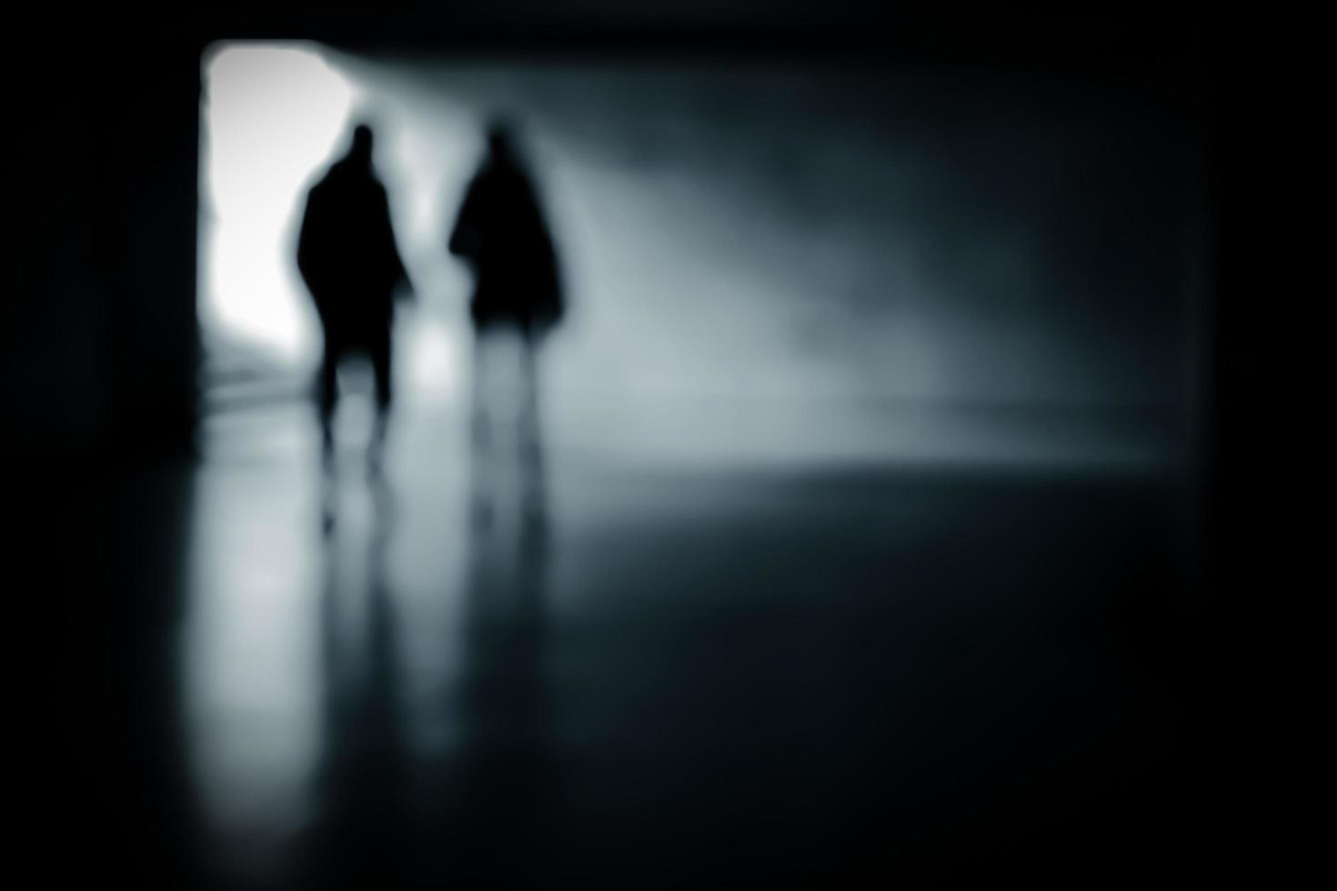 Blurry moving silhouettes in an underground passage. photo