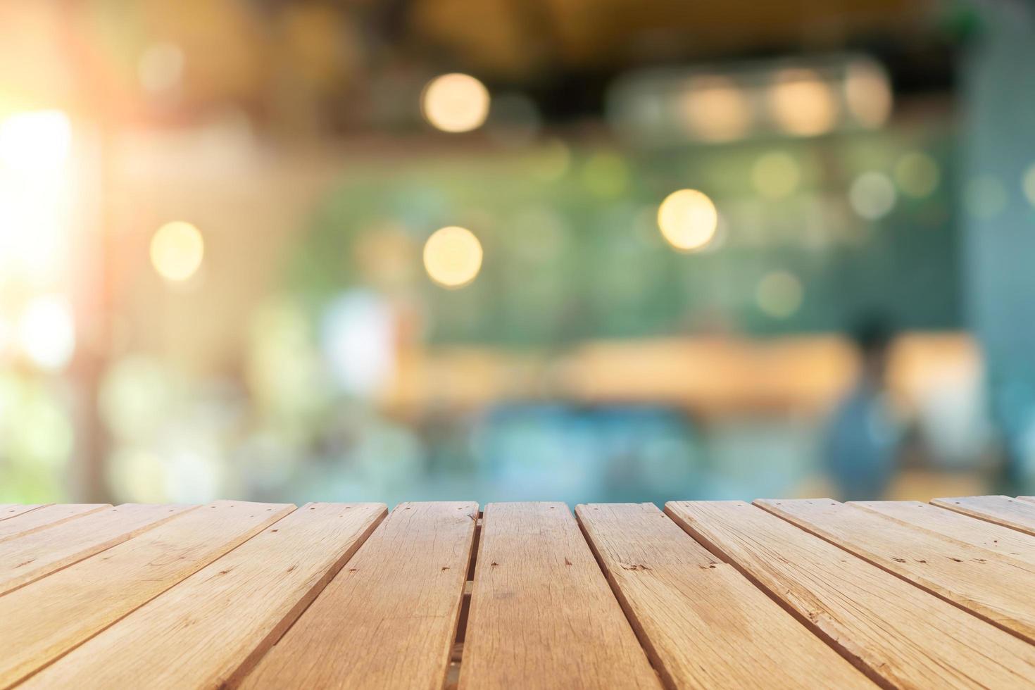 Selective focus of wooden table with a blurred coffee and restaurant cafe with customers background. photo