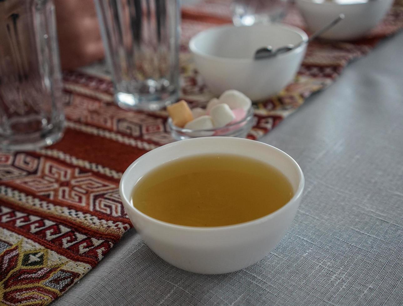 Tea in a white bowl on a colorful tablecloth photo