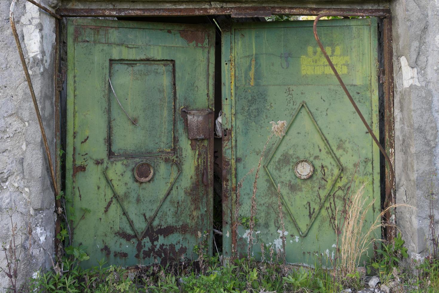 Old metal gate on the background of a gray brick wall. photo