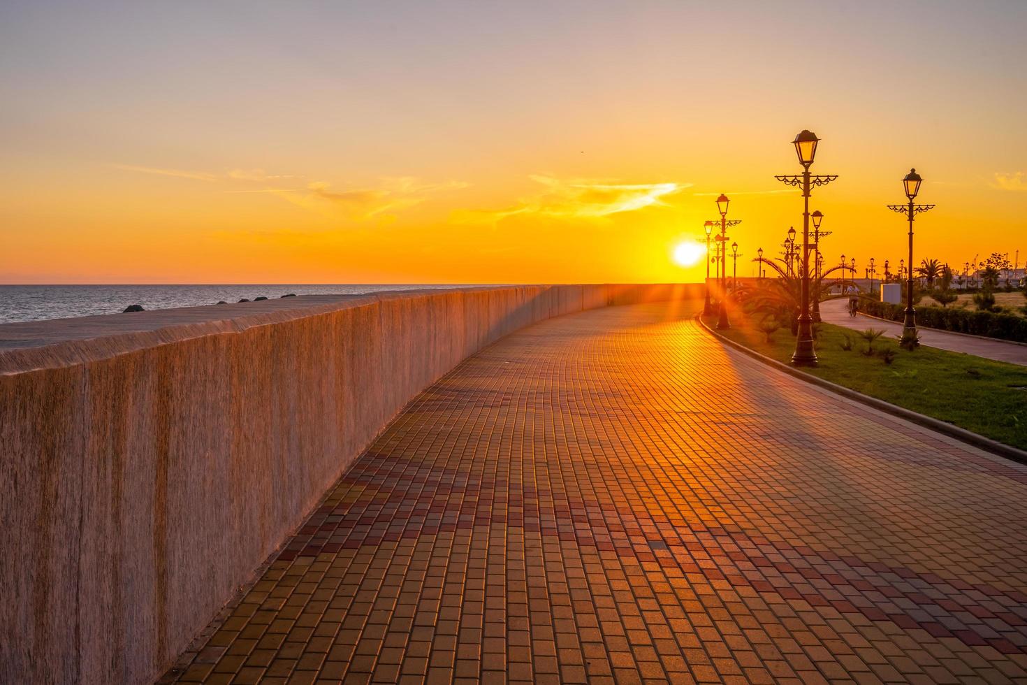 puesta de sol sobre el paseo marítimo de la ciudad turística. foto