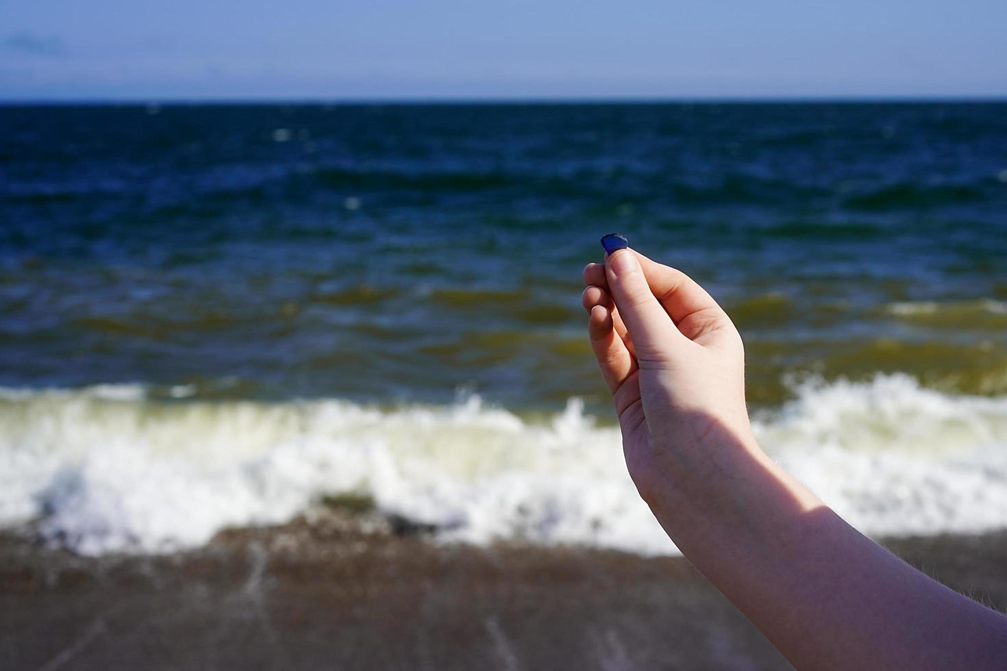 mano de niño con vidrio de mar en el fondo del mar. foto