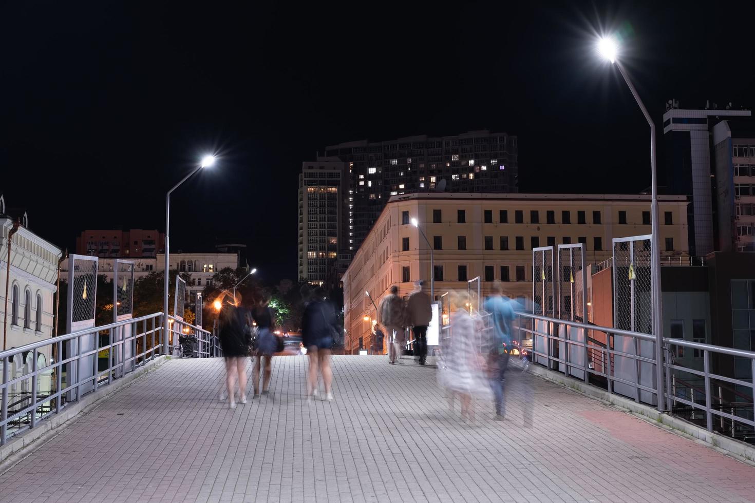 paisaje nocturno con gente en el puente de la estación de tren. foto