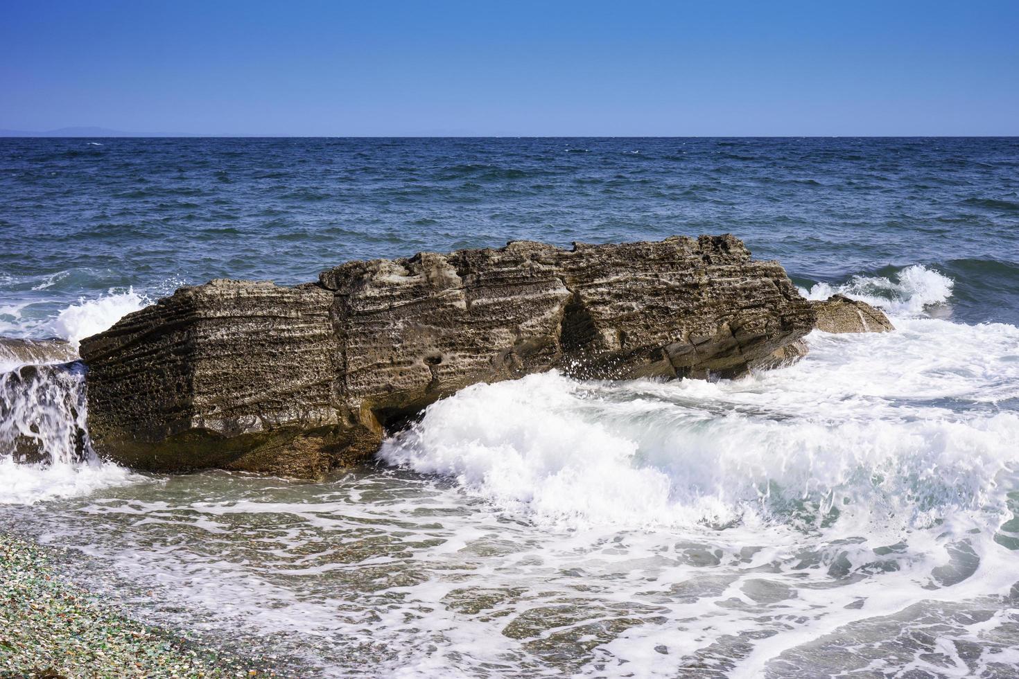 Seascape with a rock in the waves. photo