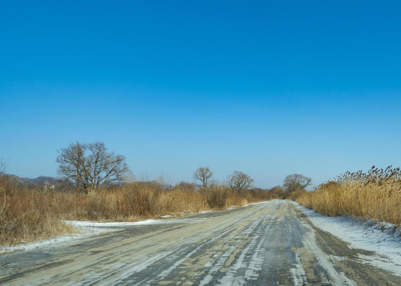 camino rural en el fondo de un paisaje invernal. foto