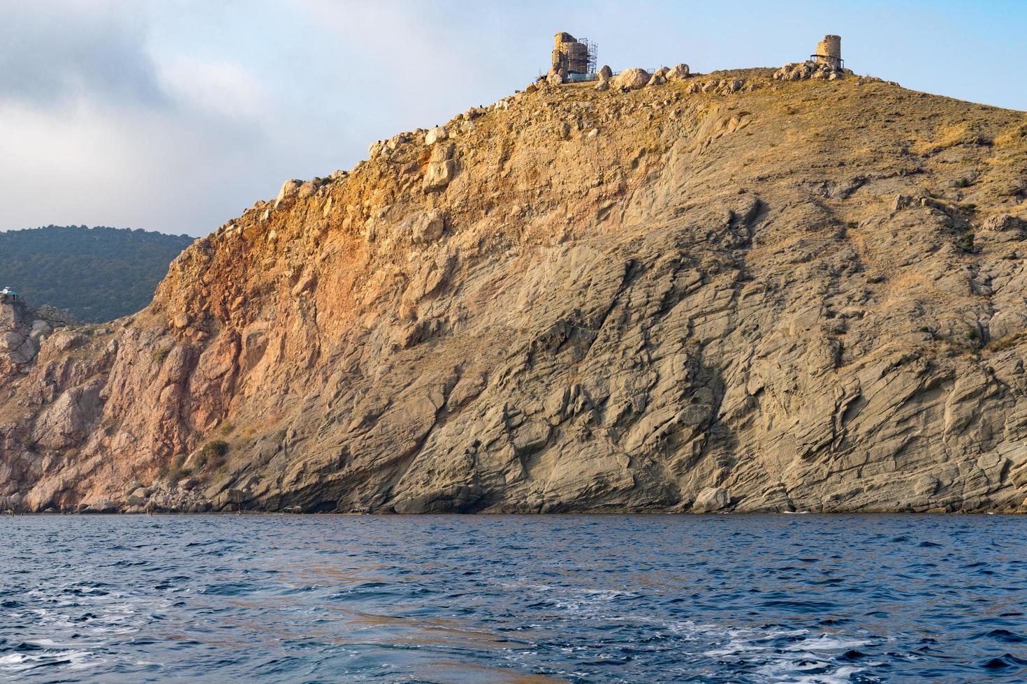 view from the sea on a rocky coastline photo