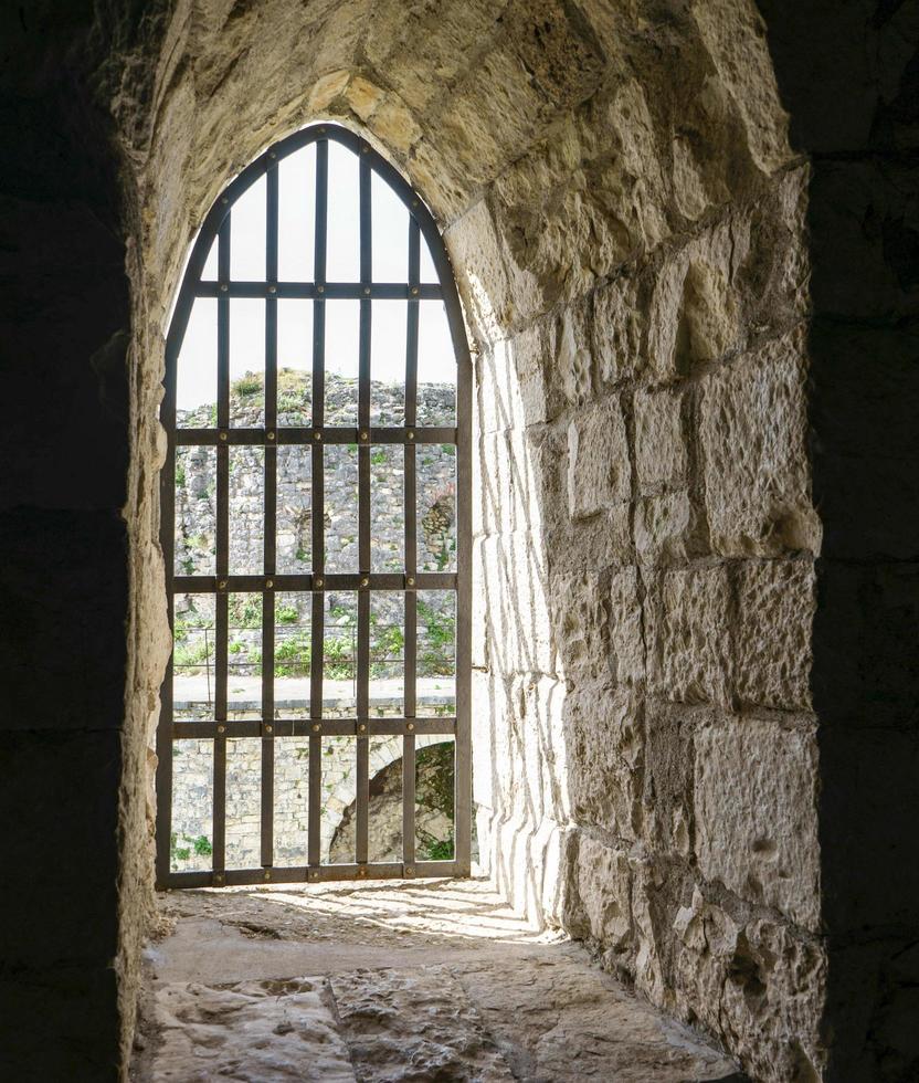 Window of an ancient fortress against a brick wall photo