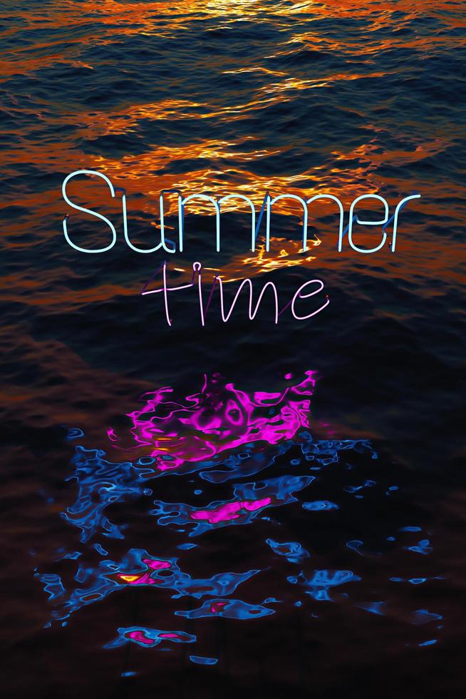 neón reflejado en el mar con las palabras horario de verano foto