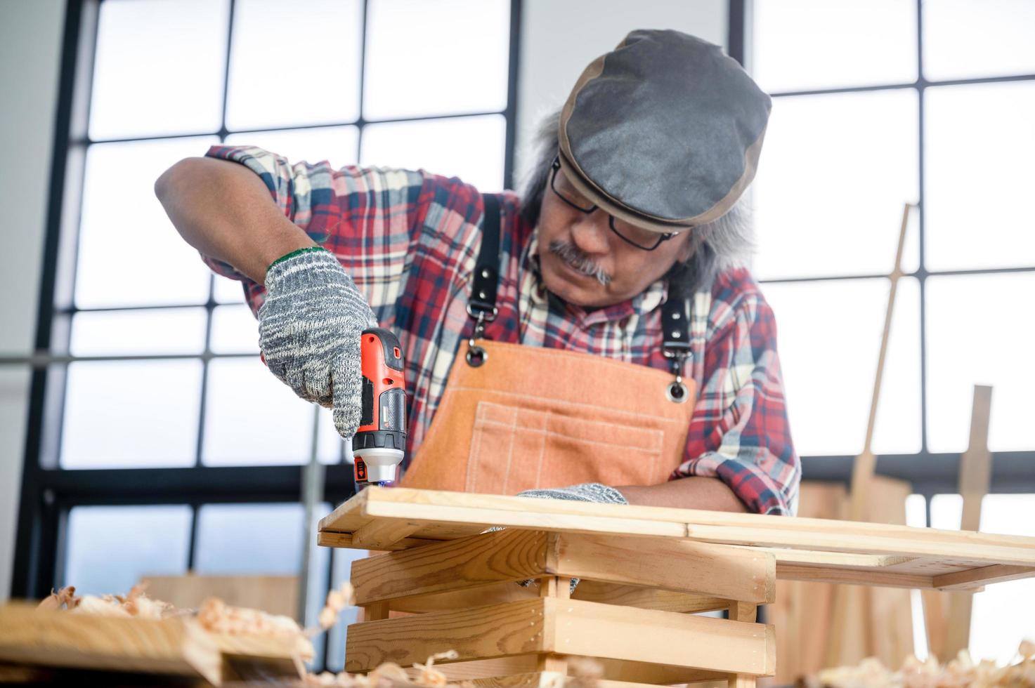 Carpintero profesional hombre que trabaja con la herramienta de la industria de la carpintería, taller de persona artesano con madera y equipos de construcción de carpintería foto