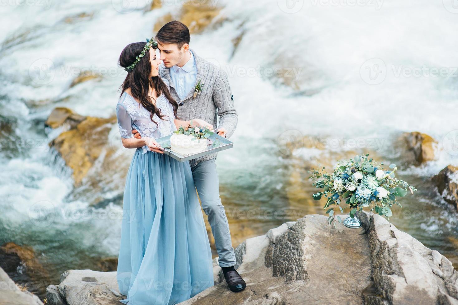 joven pareja enamorada en un río de montaña foto