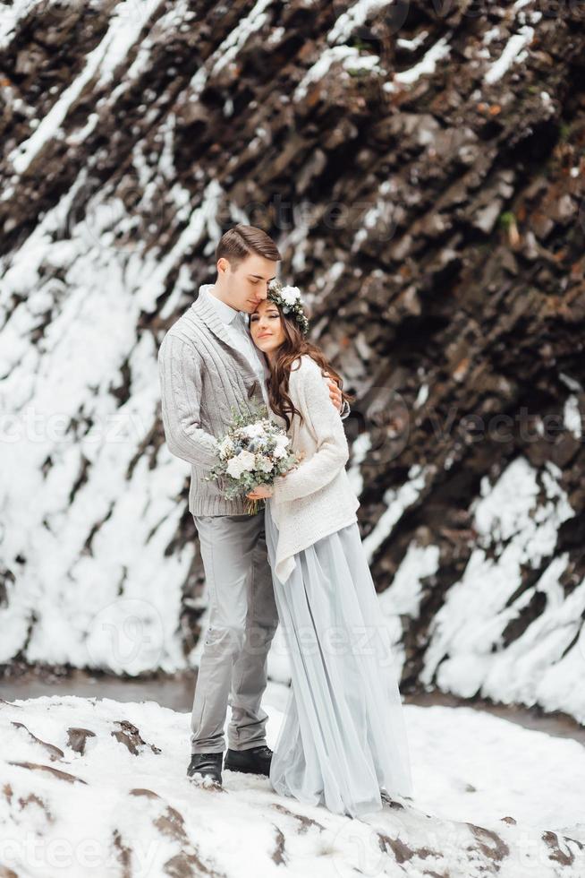 novios en la cascada de la montaña foto