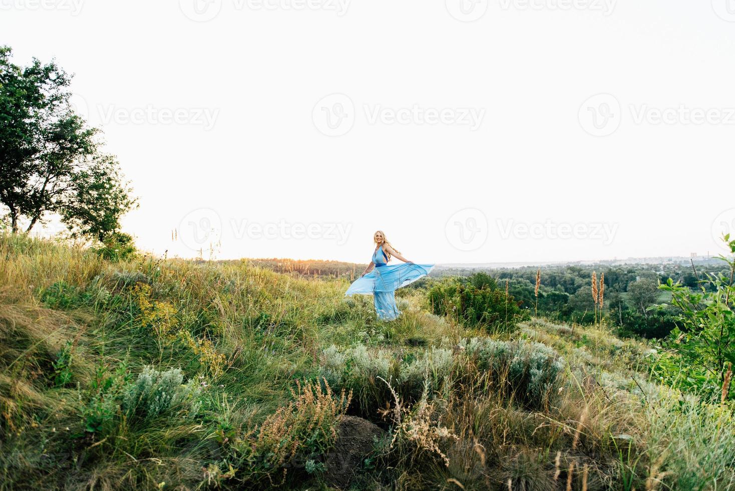 chica rubia con el pelo suelto con un vestido azul claro y un chico a la luz del atardecer foto