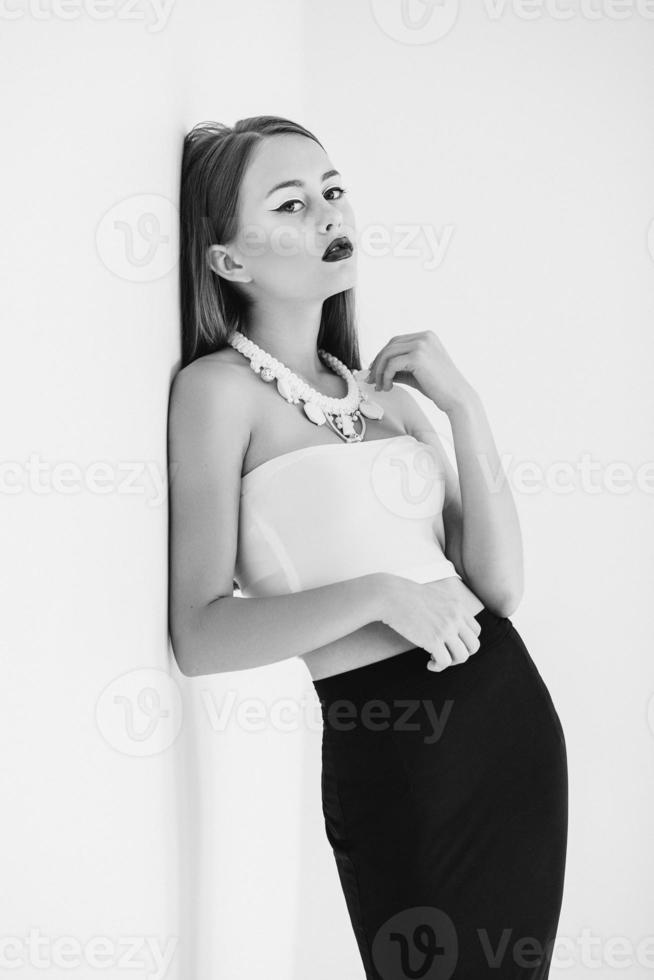 Girl in a white blouse and black skirt on a white background photo