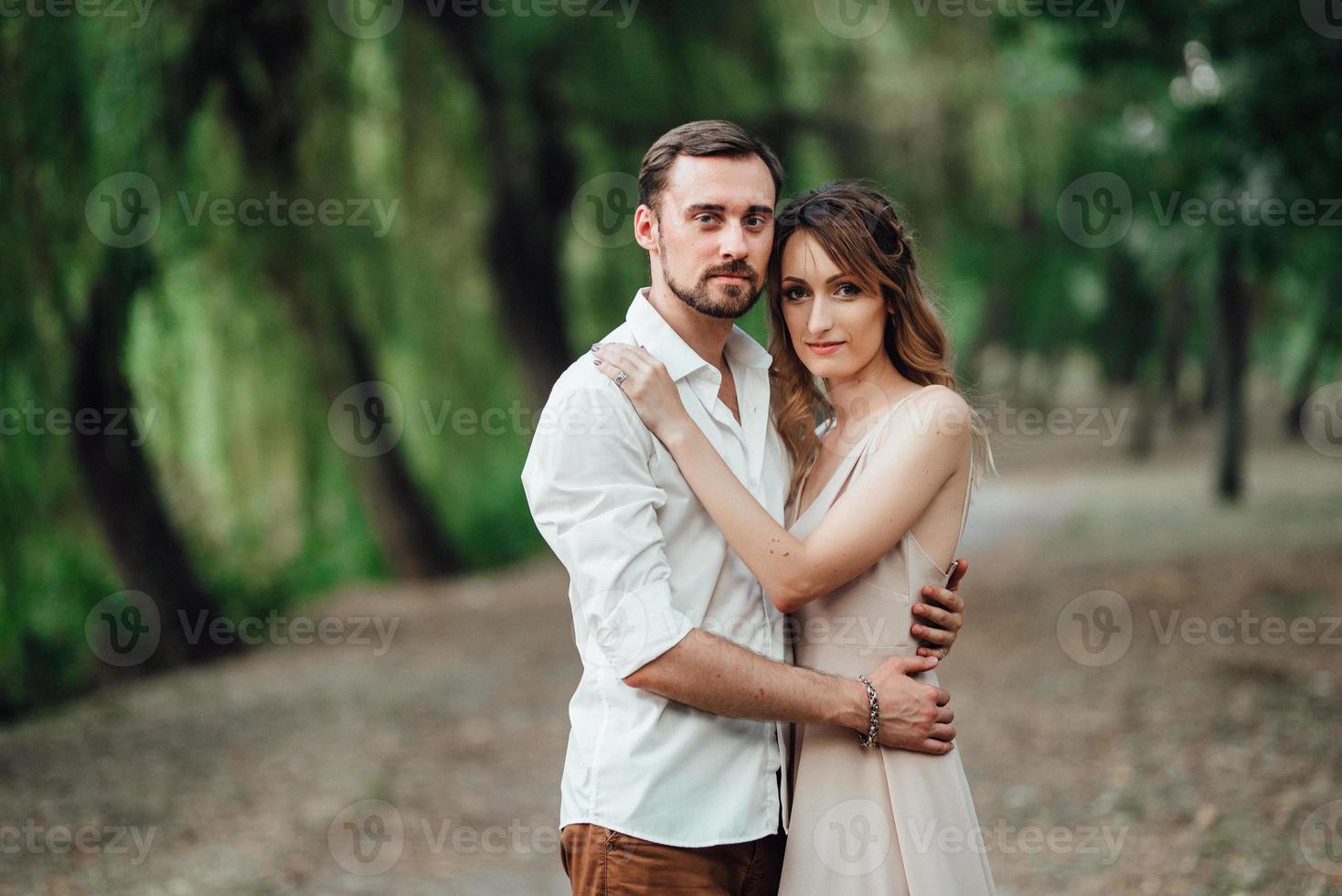 A guy and a girl are walking along the banks of a wild river overgrown photo