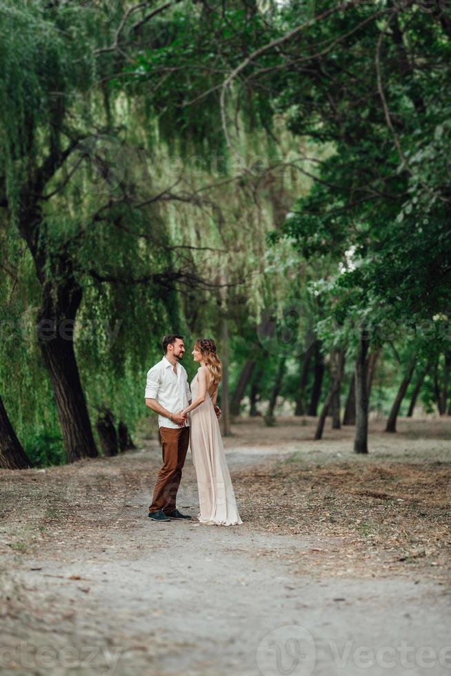 A guy and a girl are walking along the banks of a wild river overgrown photo