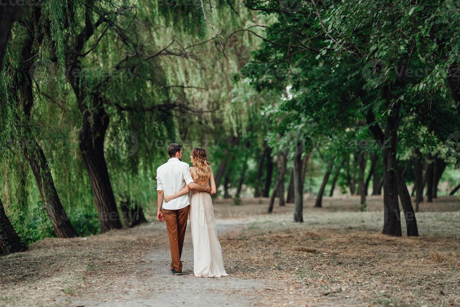 A guy and a girl are walking along the banks of a wild river overgrown photo