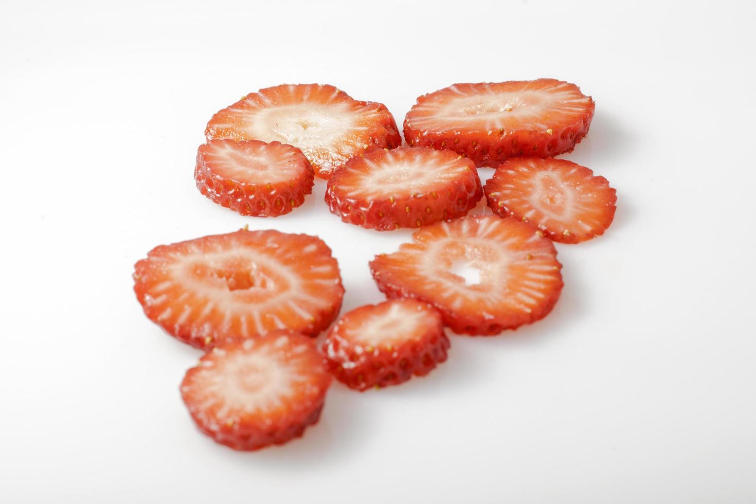 Sliced strawberries on white background photo