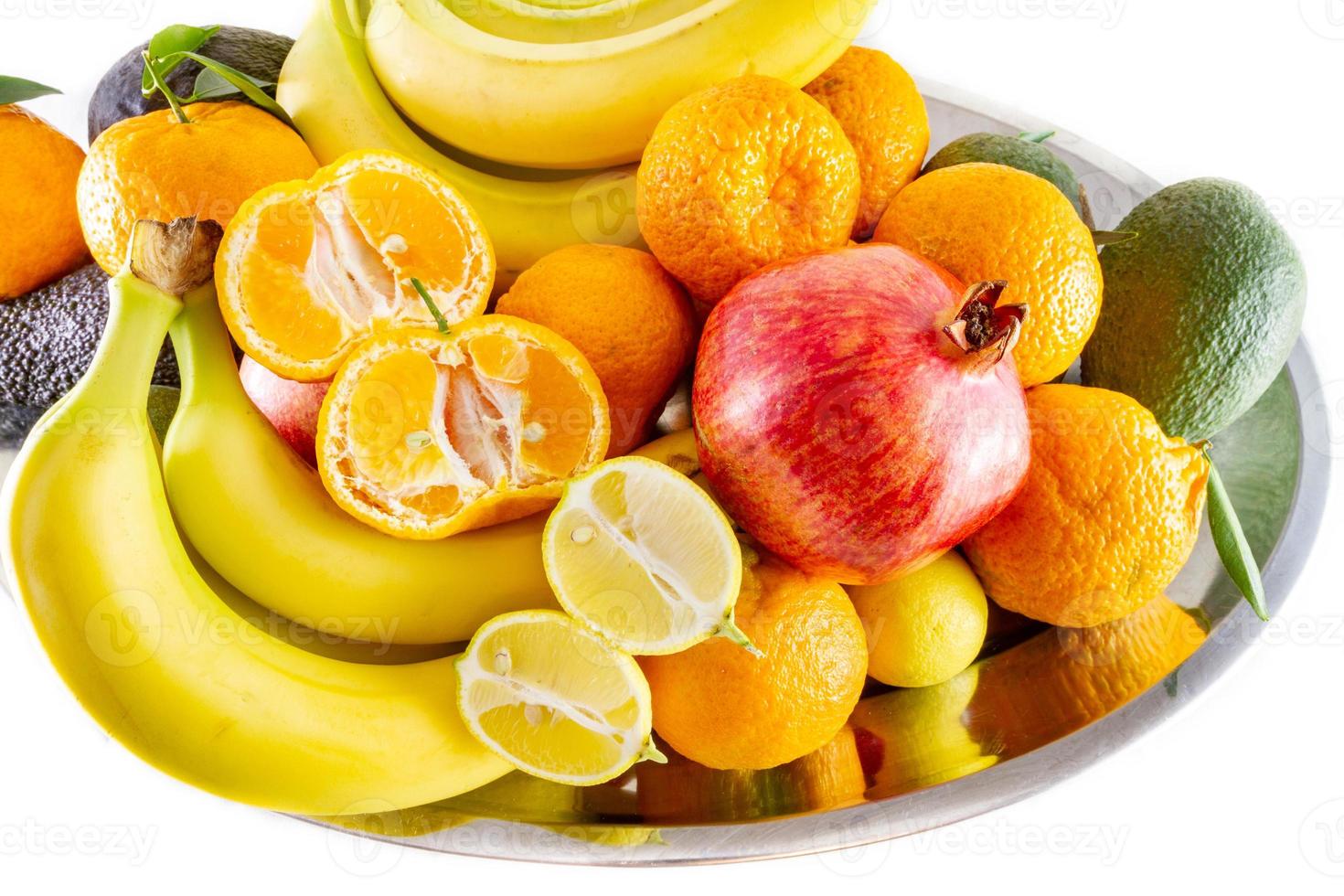 fuente variada de frutas y verduras de plátanos, granada, limón, mandarina y aguacate foto