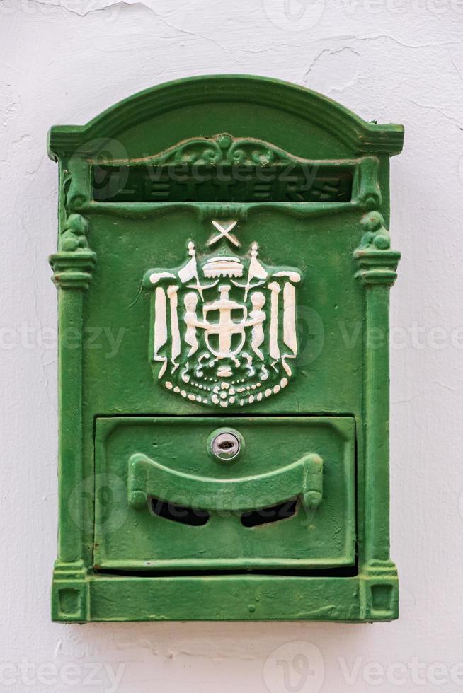 Green metal antique mailbox on a white house wall in old NIcosia, Cyprus photo