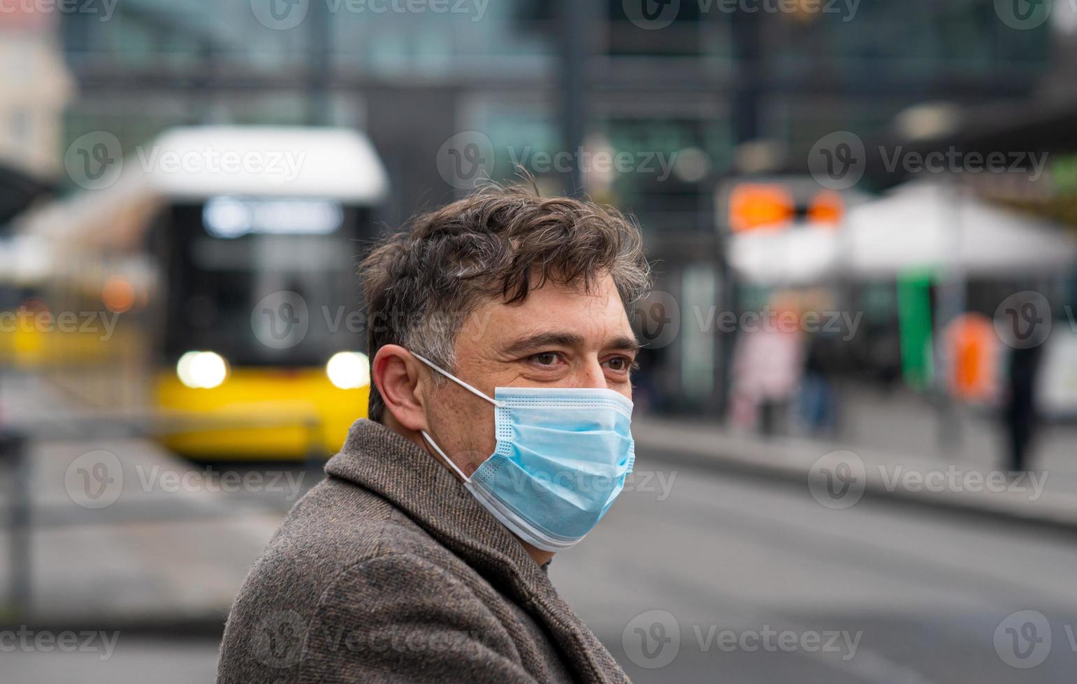 usando máscaras protectoras al aire libre en la ciudad foto