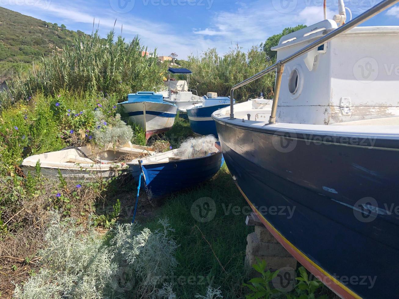 Barcos de pesca abandonados en descomposición en un campo de hierba foto