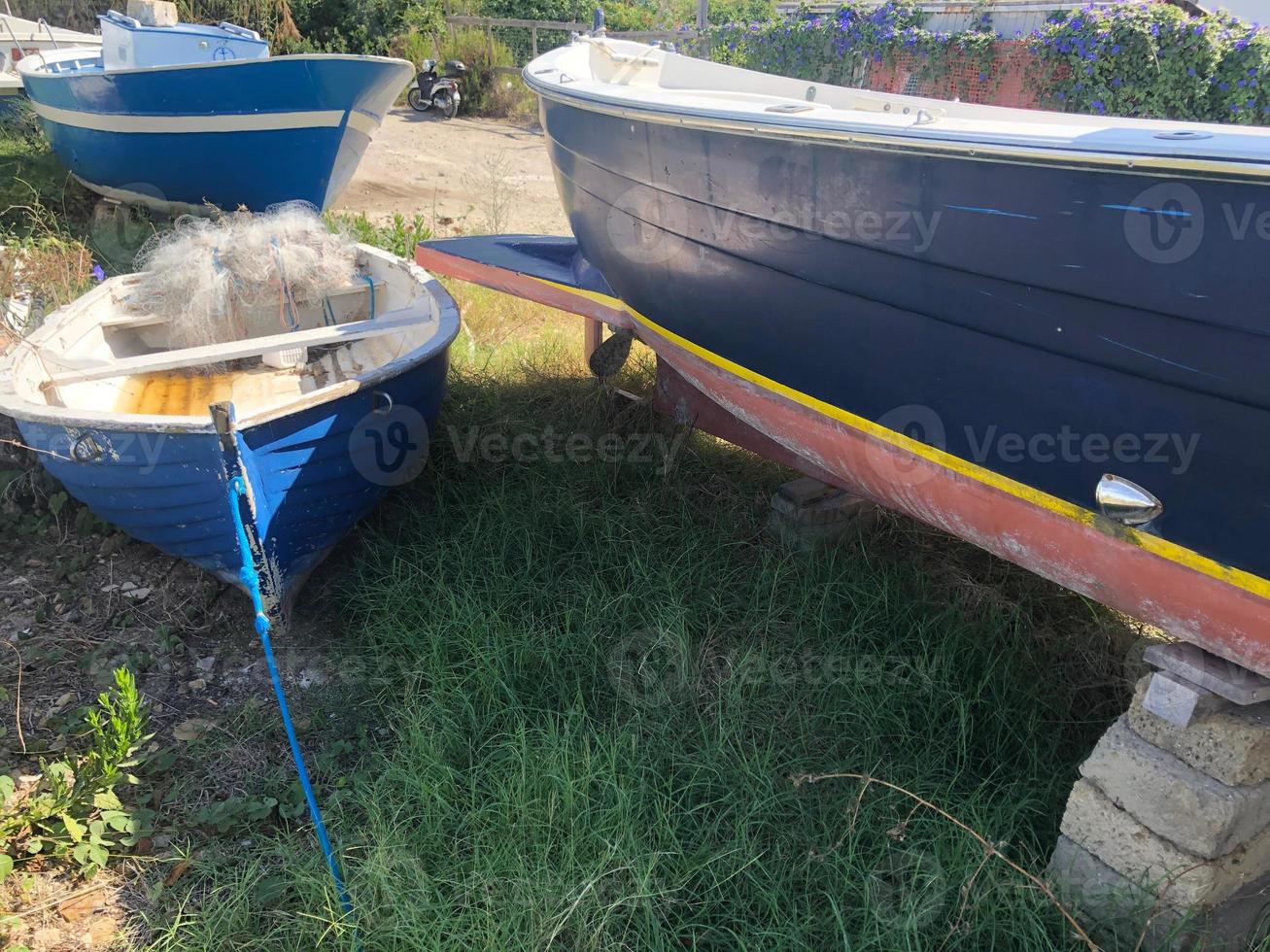 Barcos de pesca vacíos en descomposición en un campo de hierba foto