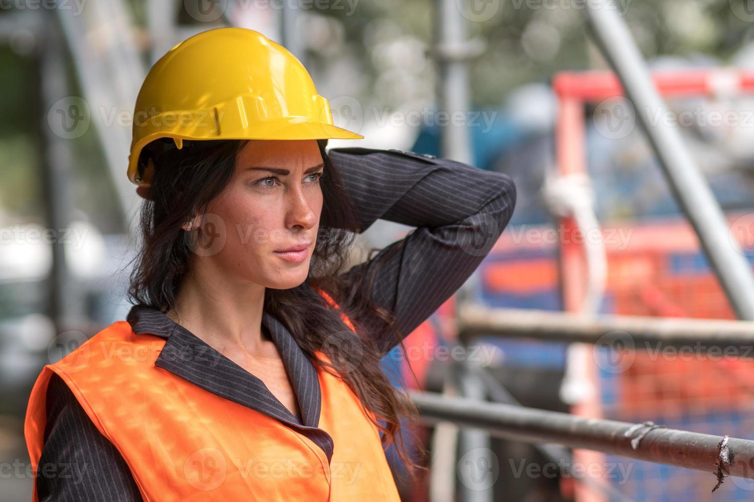 Construction worker fixing her safety helmet photo