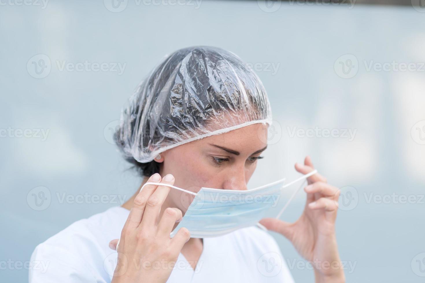 Doctora poniéndose su mascarilla facial foto
