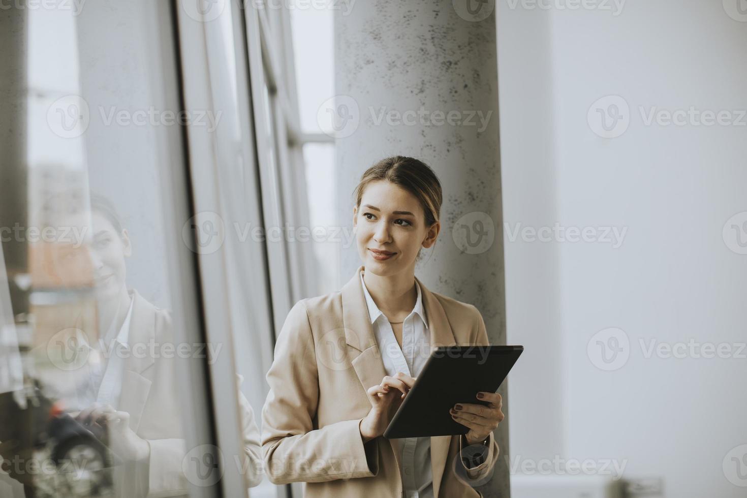 mujer sosteniendo tableta en la oficina moderna foto