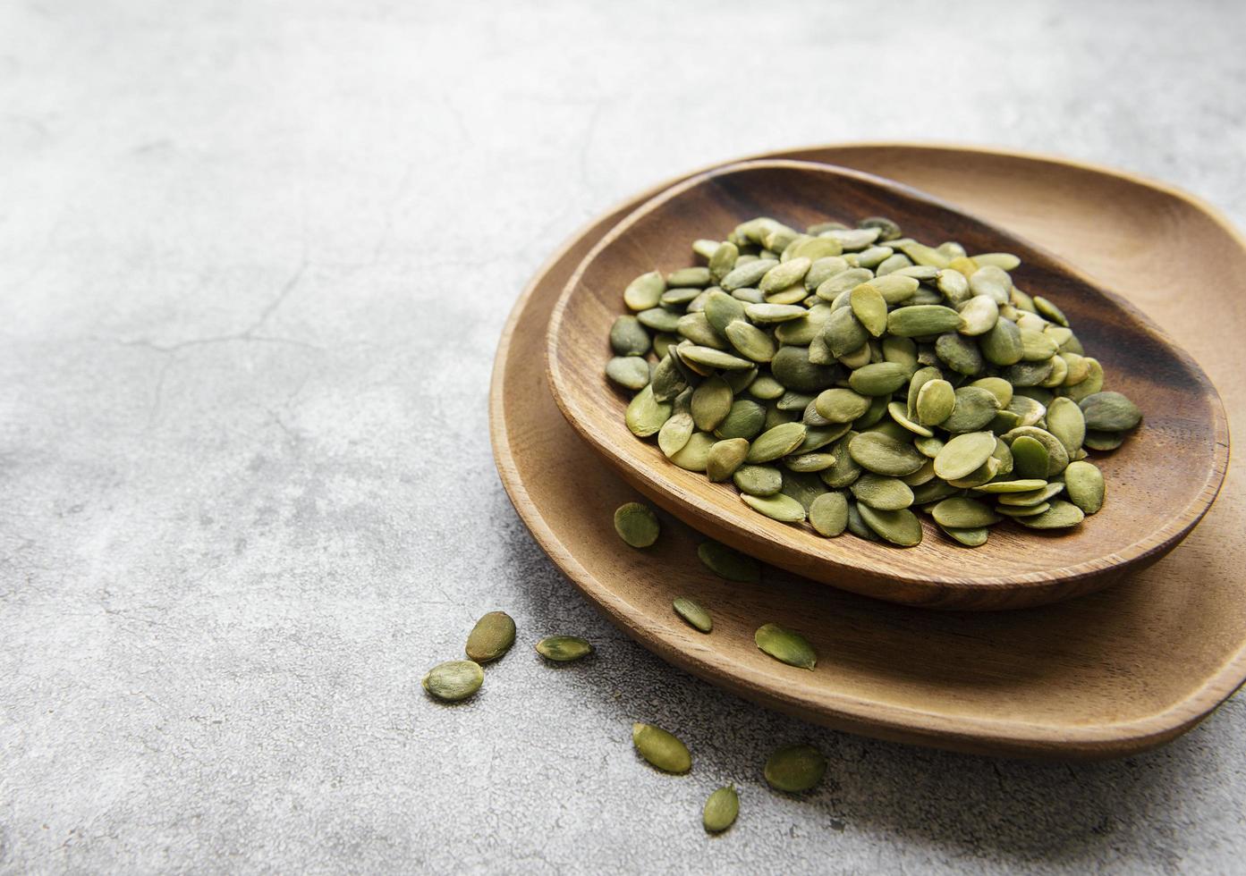 Wooden plate with pumpkin seeds photo