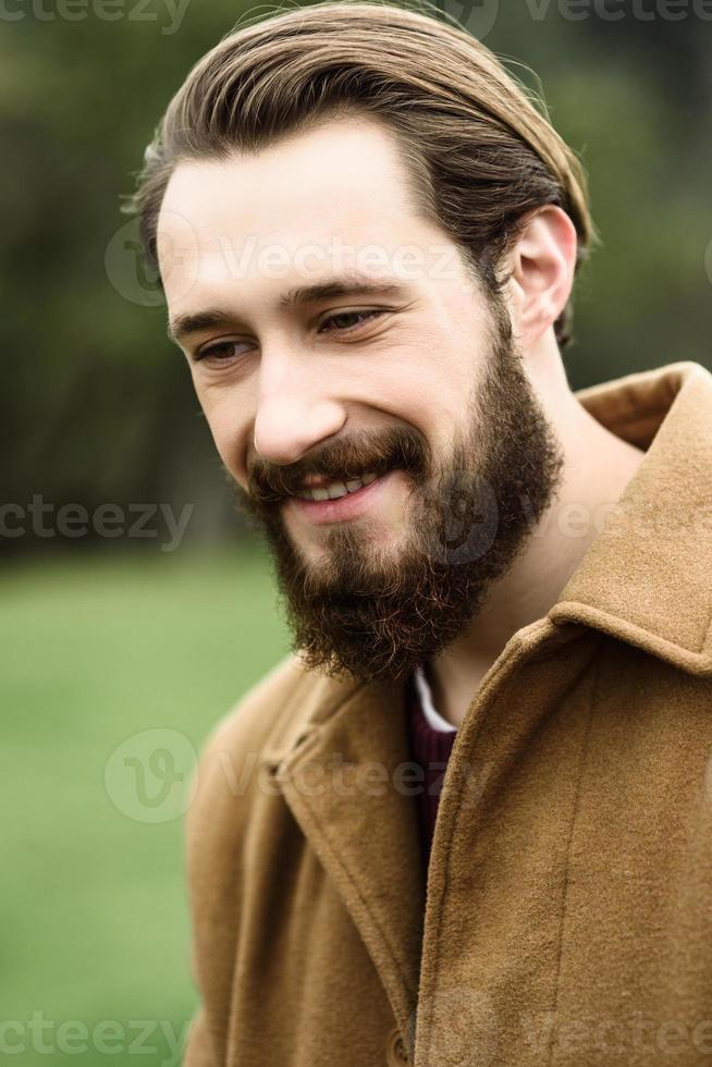 hombre sonriente con un abrigo marrón foto