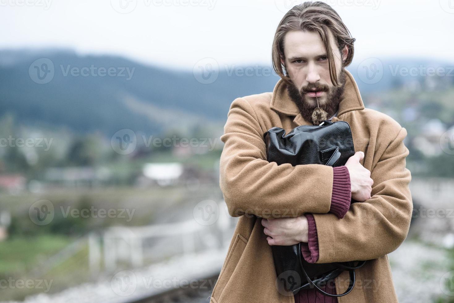 hombre con un abrigo marrón foto