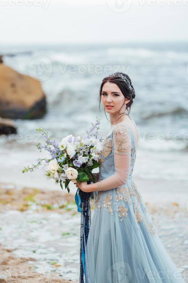 novia con un ramo de flores en la playa foto