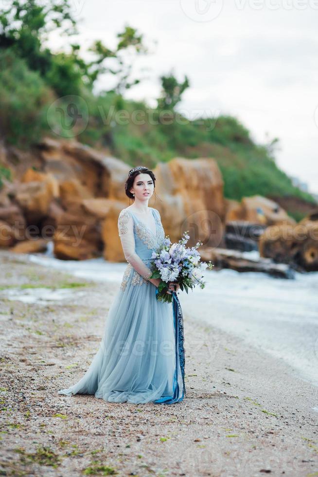 novia con un ramo de flores en la playa foto