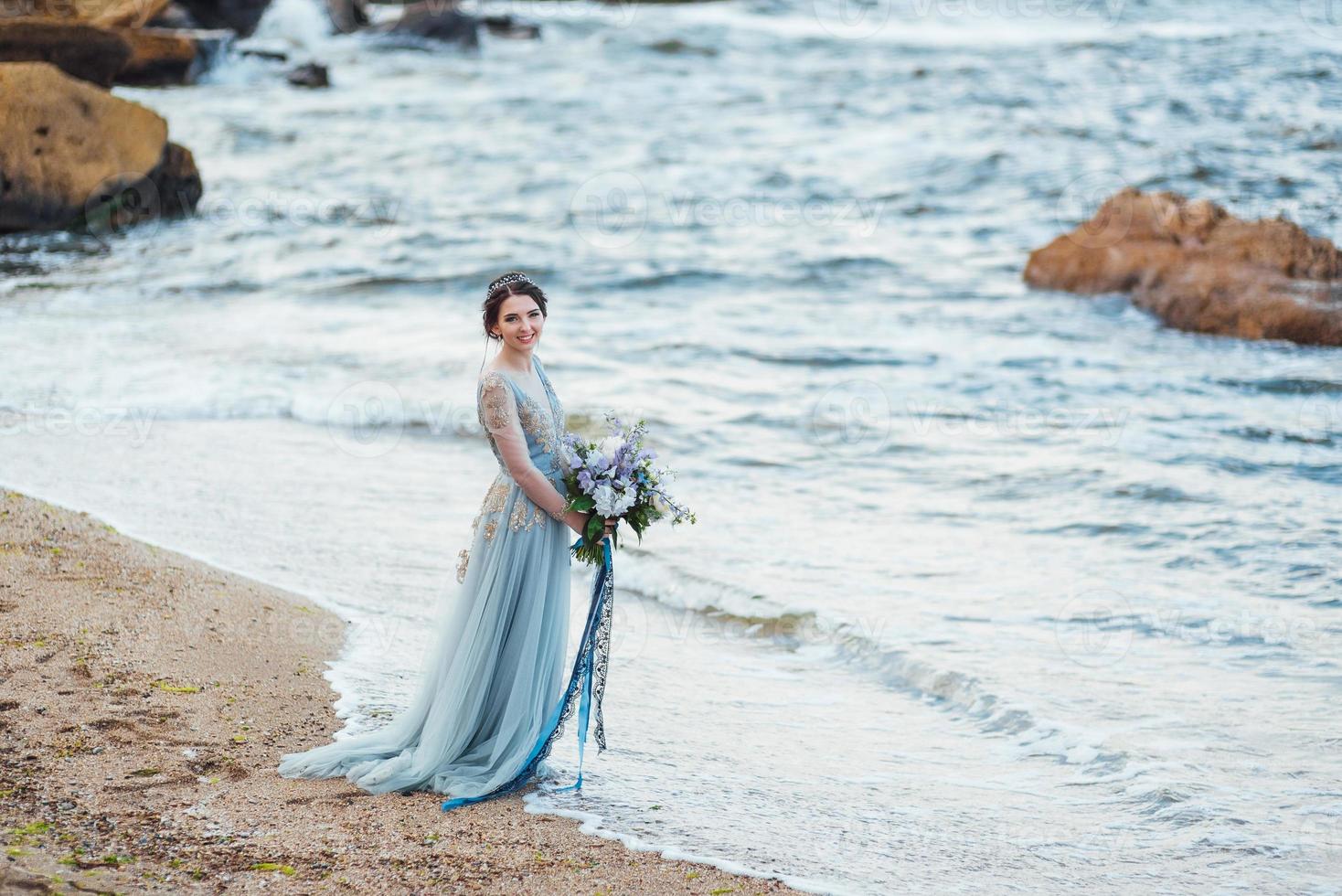 novia con un ramo de flores en la playa foto
