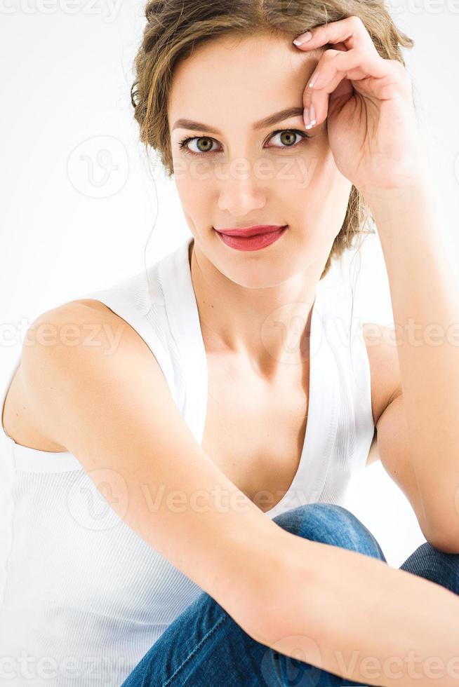 cheerful girl in a white tshirt and dark blue jeans in the studio on a white background photo