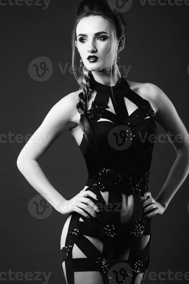 white girl model on a dark background in a dress made of cut stripes photo