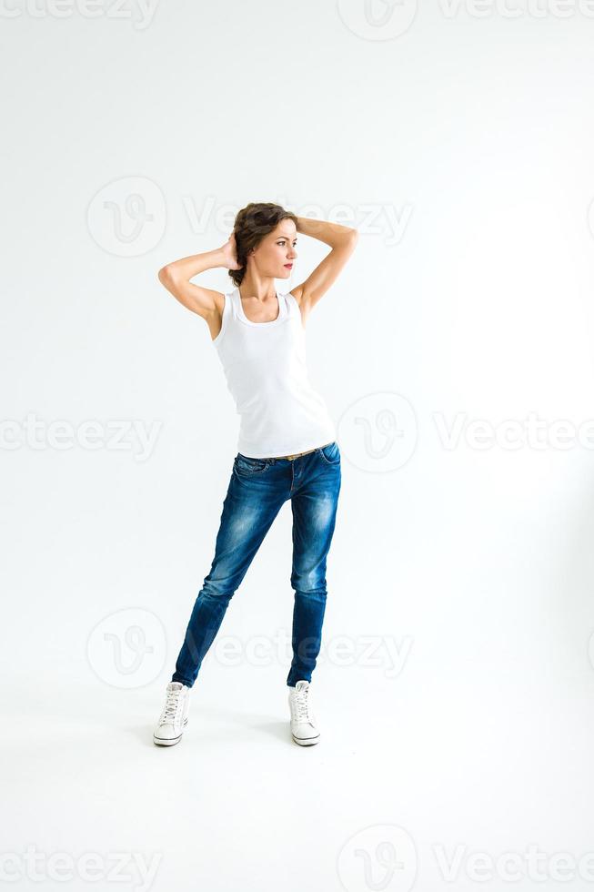 Chica Alegre En Una Camiseta Blanca Y Jeans Azul Oscuro En El Estudio Sobre Un Fondo Blanco 2375880 Foto De Stock En Vecteezy