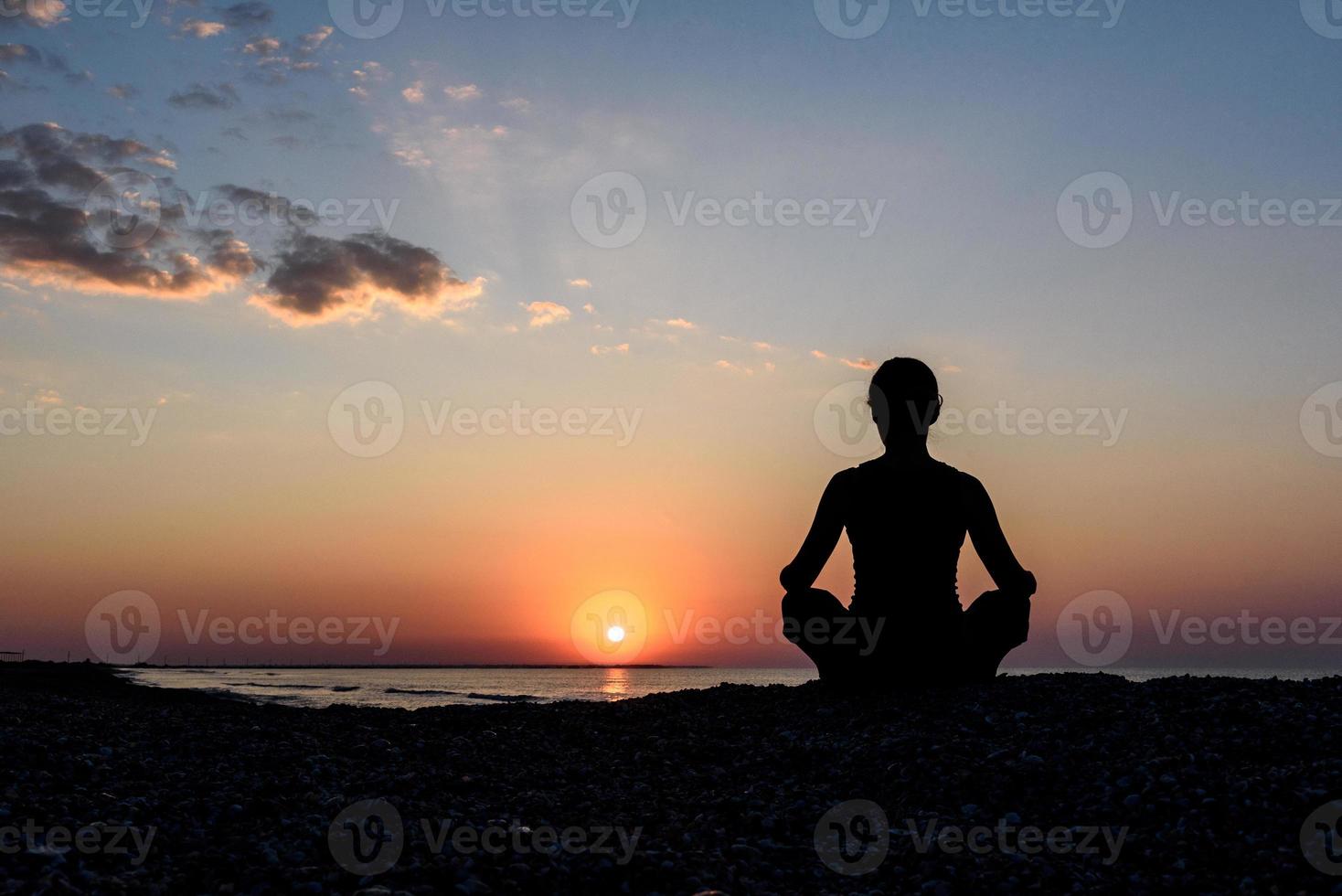 chica en la playa al amanecer en yoga assana foto