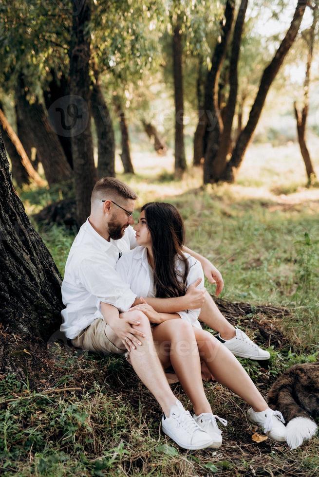 young couple in love a guy with a beard and a girl with dark hair in light clothes photo