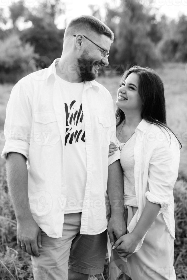 young couple in love a guy with a beard and a girl with dark hair in light clothes photo