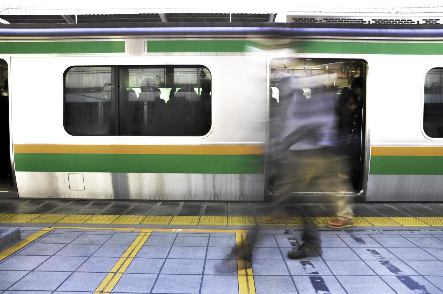 Tokio, Japón - 13 de noviembre de 2014 - El movimiento de los pasajeros que caminan en el andén de la estación jr durante la hora punta en Tokio, Japón foto