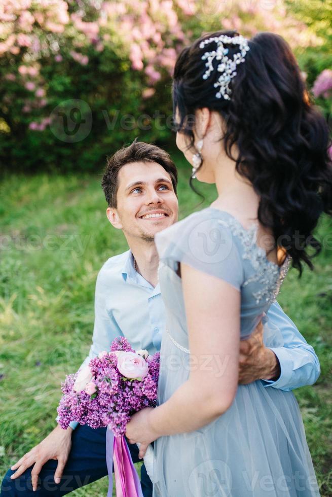 a guy and a girl walk in the spring garden of lilacs photo
