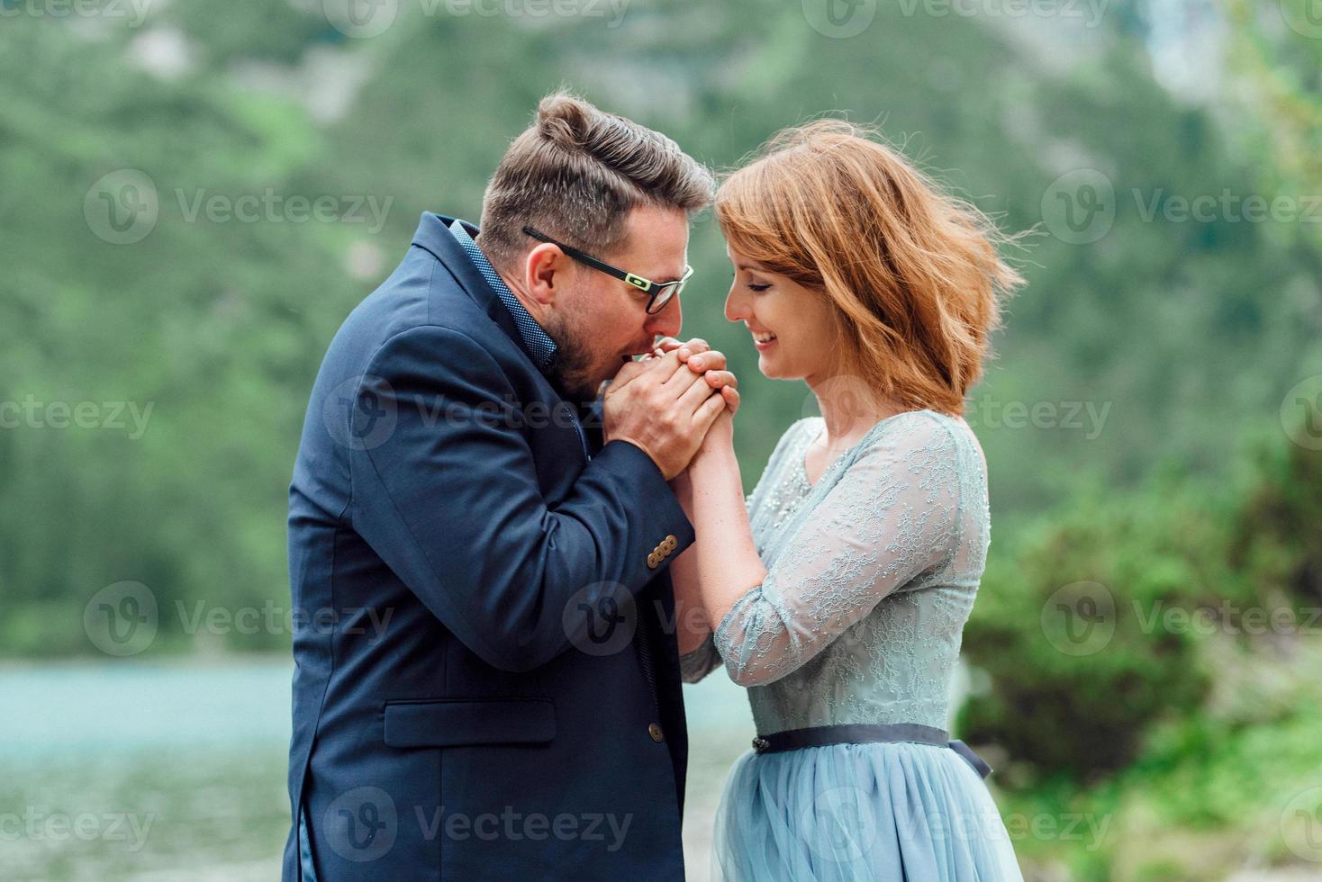 pareja joven en un paseo cerca del lago rodeado por las montañas foto