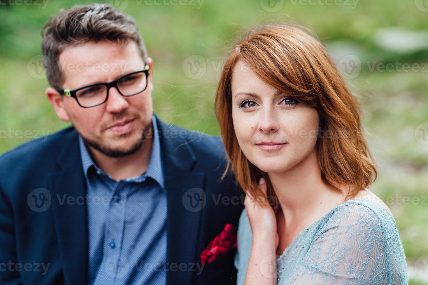 young couple on a walk near the lake surrounded by the mountains photo