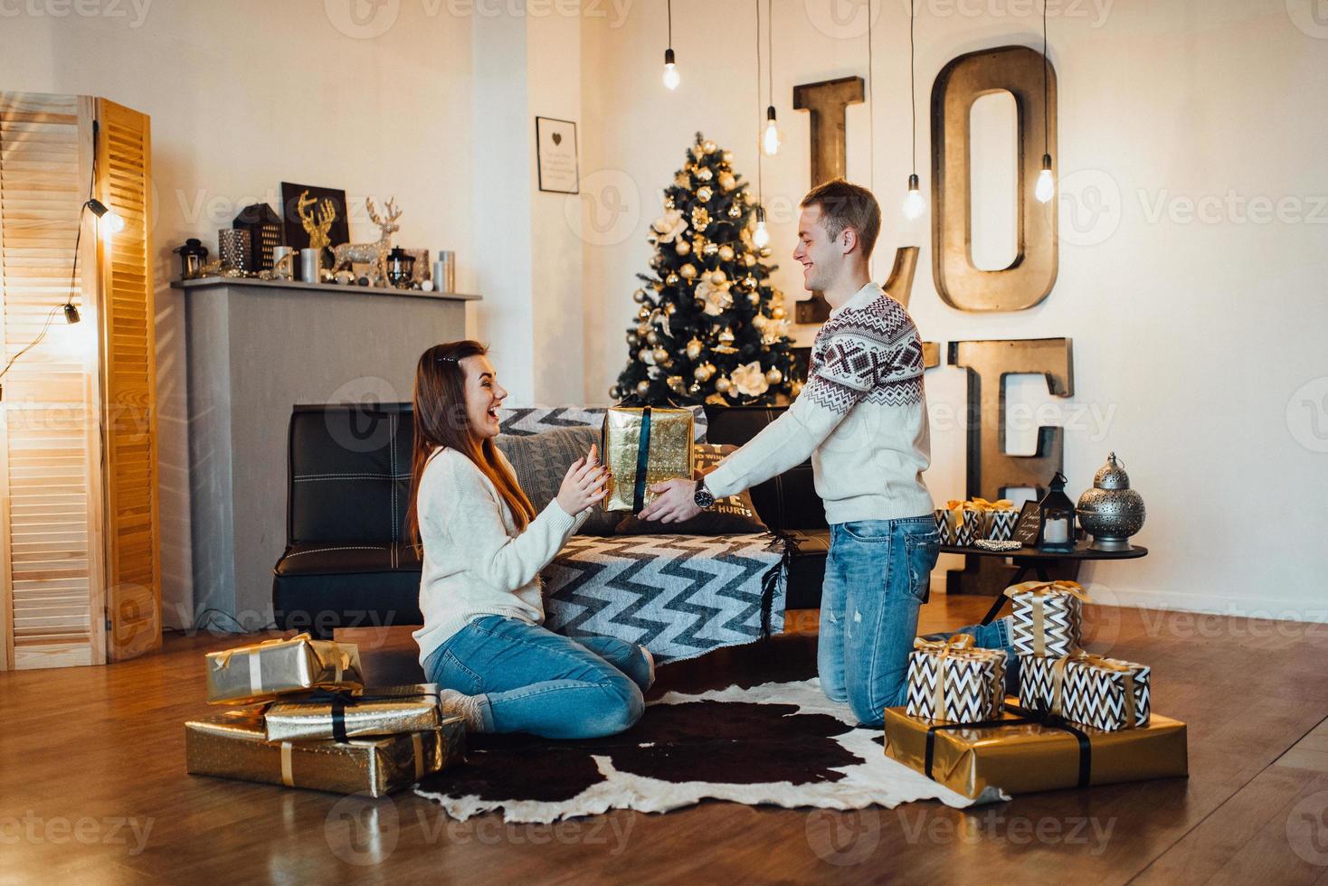 guy and a girl celebrate the new year together and give each other gifts photo