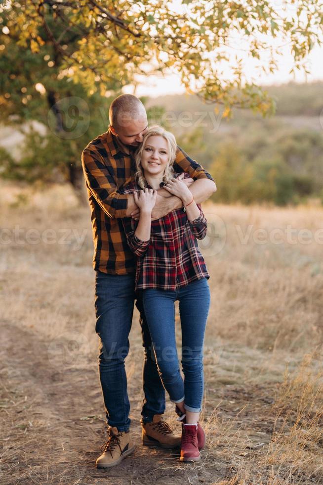 Cheerful guy with a board and a blonde girl for a walk in plaid shirts photo