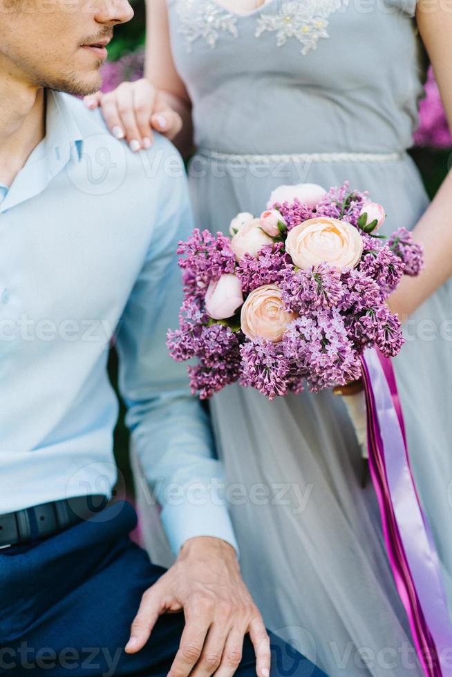 un chico y una chica caminan en el jardín de primavera de lilas foto