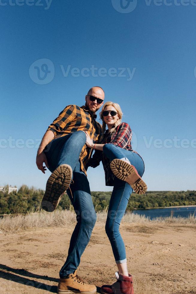 Guy and girl in caged shirts and trekking shoes photo
